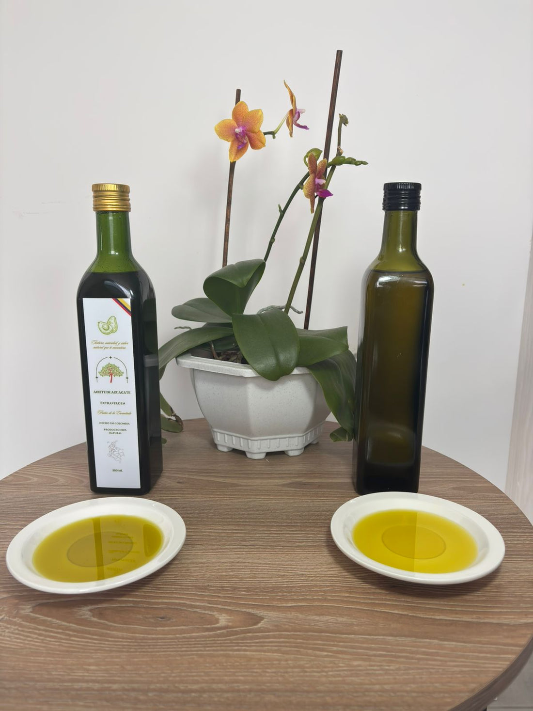 Dos botellas de aceite de aguacate con sus platos de aceite, comparando color y textura