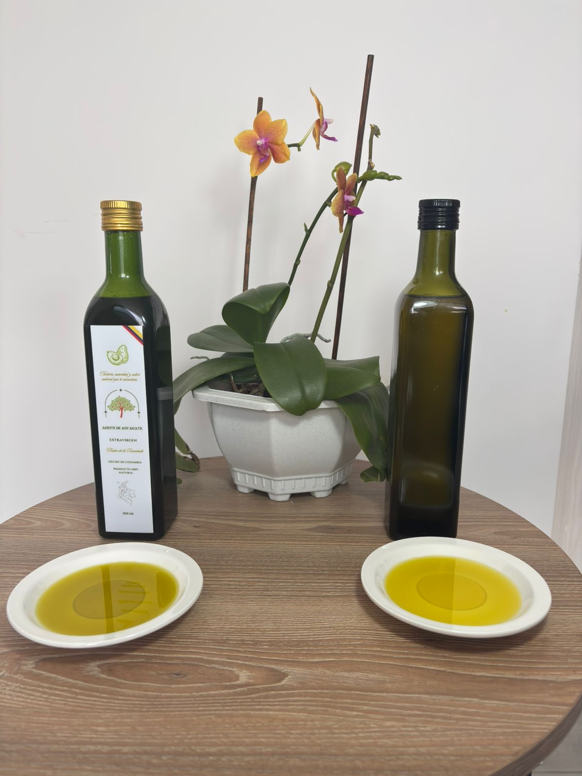 Dos botellas de aceite de aguacate con sus platos de aceite, comparando color y textura